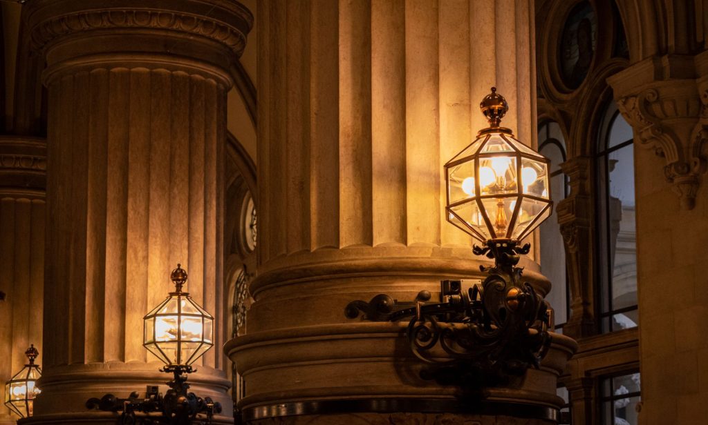 Moody interior of a Hamburg cathedral with illuminated columns and lanterns.