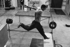 Action shot of a parkour athlete leaping on indoor obstacle course, showcasing agility and strength.