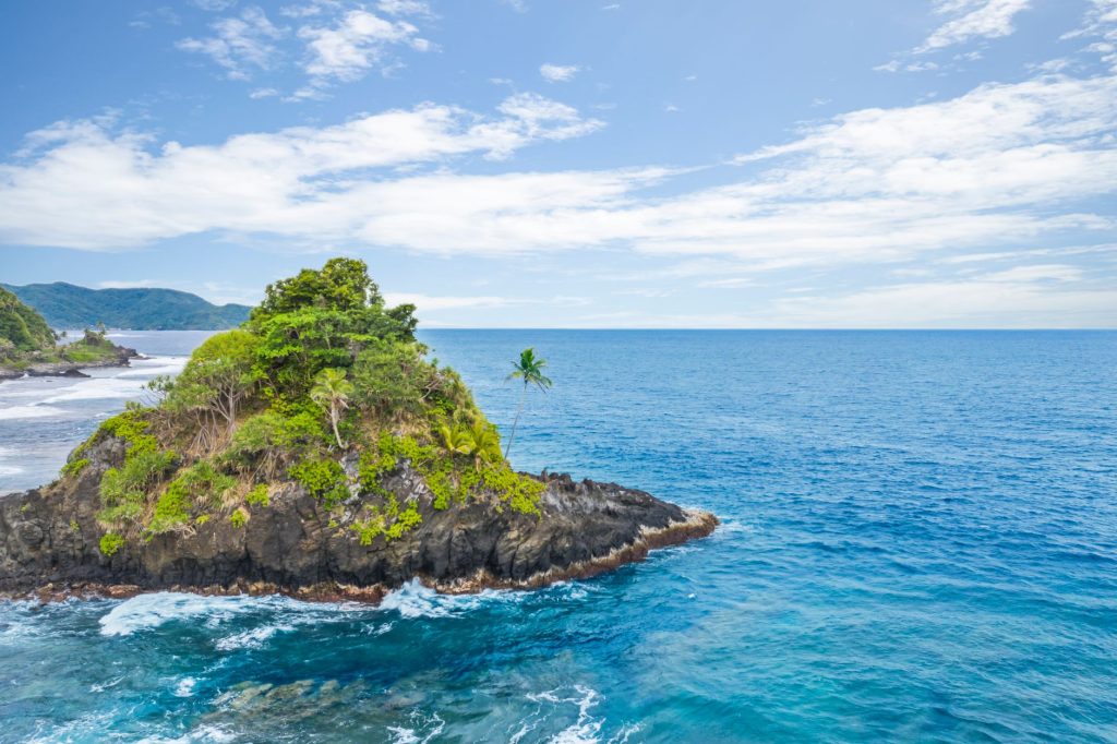 Explore the stunning Alega Beach with vibrant turquoise waters and lush greenery in American Samoa.