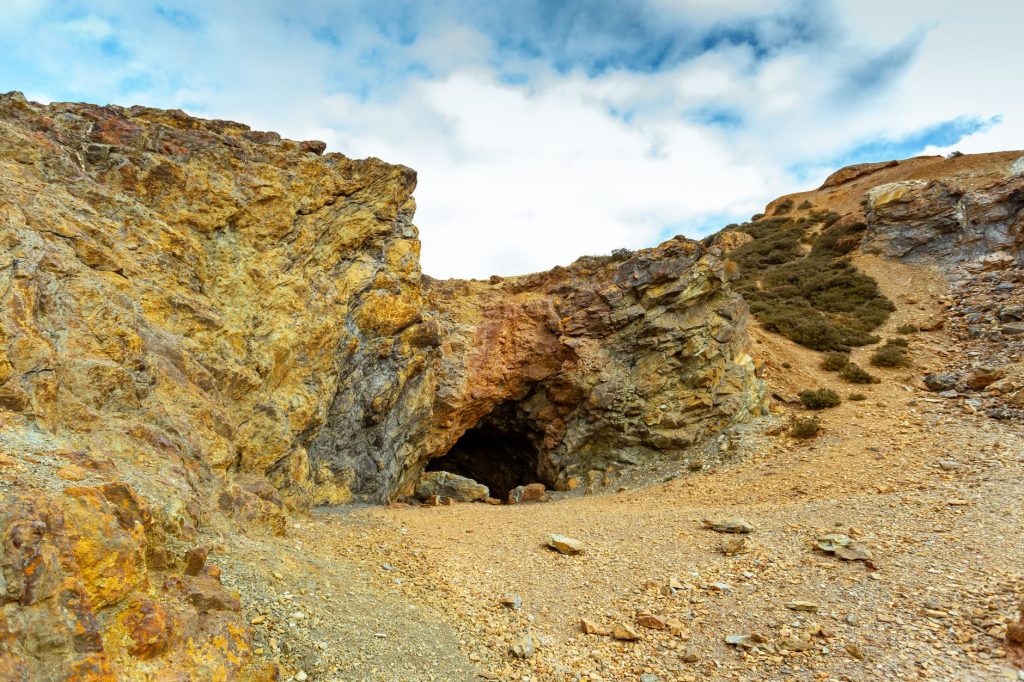 Explore the rugged terrain of Parys Mountain with its striking rocky cave and earthy tones.